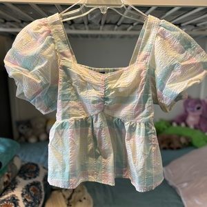 A short puffed sleeve loose pastel blouse.